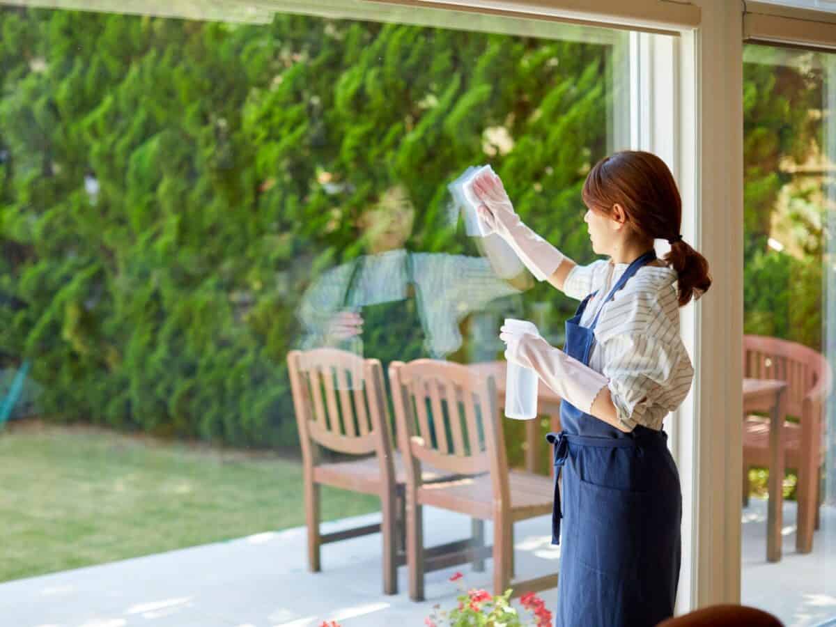 Medewerker poetst een tuinraam